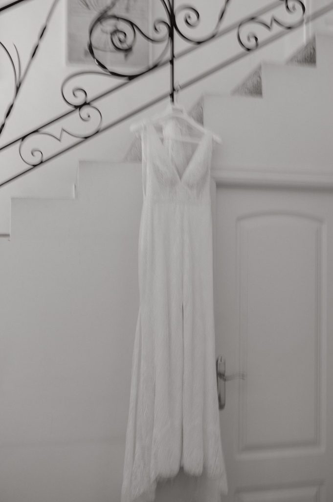 Vestido de novia blanco colgado en escalera elegante.