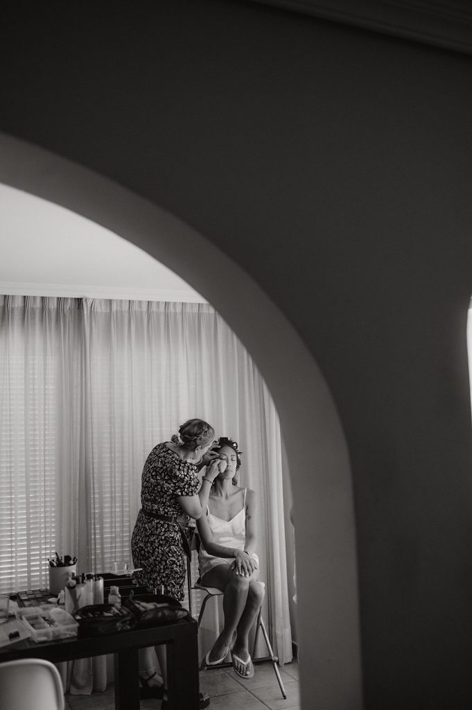 Maquilladora arreglando a una novia en silla