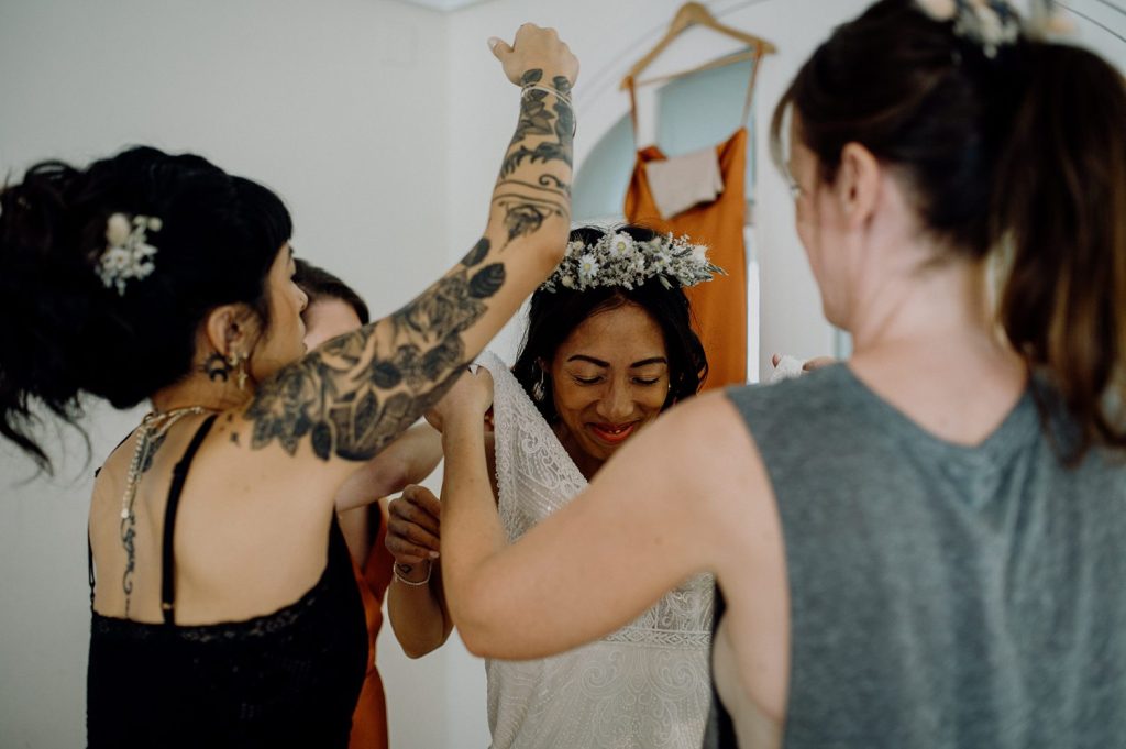 Novia vistiéndose ayudada por amigas